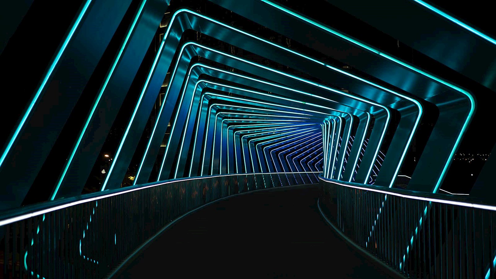 Corridor curving off into background with blue neon lights 